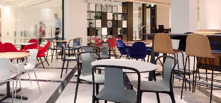 An assortment of tables, chairs and stools set up in a bright room