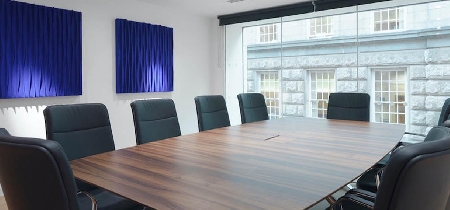 A wooden conference table with ten chairs