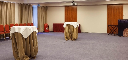 An event space set up with two high, covered tables